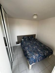 Un pequeño dormitorio con una cama en la esquina en Appartement 2CH, clim, piscine, garage, mer, en Le Grau-du-Roi