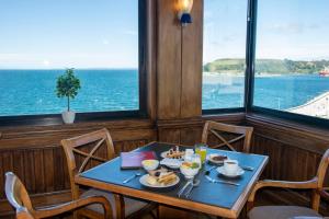 uma mesa com comida e vista para o oceano em abba Presidente Suites Puerto Montt em Puerto Montt