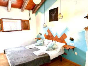 een slaapkamer met een groot bed met blauwe muren bij Catedral Apartments in Valencia