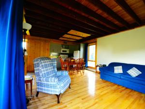 ein Wohnzimmer mit einem blauen Sofa und einem Tisch in der Unterkunft Station touristique Pin Rouge in New Richmond