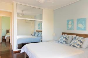 ein Schlafzimmer mit zwei Betten und einem großen Spiegel in der Unterkunft Vouliagmeni Sea and Sun Apartment in Athen