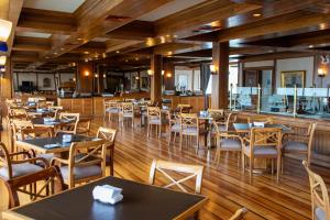 um restaurante com pisos e mesas e cadeiras de madeira em abba Presidente Suites Puerto Montt em Puerto Montt
