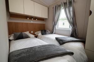 two beds in a room with a window at Mendip Close in Burnham on Sea