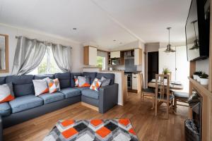 a living room with a blue couch and a kitchen at Mendip Close in Burnham on Sea