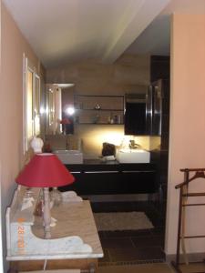 アンデルノ・レ・バンにあるVilla Alluroの洗面台、テーブル上の赤いランプが備わる客室です。