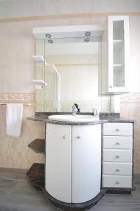 a bathroom with a white sink and a mirror at Casa de playa en un pequeño paraíso in Isla de Arosa