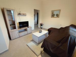 a living room with a couch and a tv at Garden Home 2 in Kalymnos