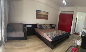 een slaapkamer met een bed en een stoel erin bij Leli Apartments in Ulcinj