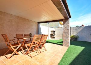 a patio with a wooden table and chairs at Casa de playa en un pequeño paraíso in Isla de Arosa