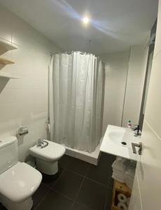 a white bathroom with a toilet and a sink at Balcón del atardecer in Barbate