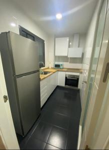 uma cozinha com armários brancos e um frigorífico em Balcón del atardecer em Barbate