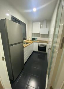 a kitchen with white cabinets and a refrigerator at Balcón del atardecer in Barbate
