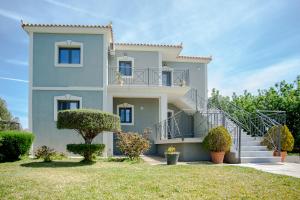 a house with a staircase in front of it at Aella Apartment in Skala Kefalonias