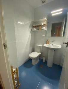 a bathroom with a white toilet and a sink at Balcón del atardecer in Barbate +2 photos