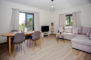 a living room with a couch and a table with chairs at Aella Apartment in Skala Kefalonias