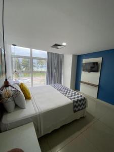 a bedroom with a bed and a large window at Imperial Tambau By Loui in João Pessoa