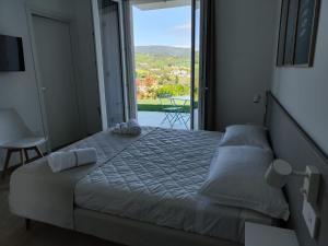a bedroom with a large bed with a large window at Le Nereidi Green Resort Elisa in Sirolo