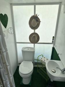 a bathroom with a toilet and a window and a sink at Beach & Calm at Fare Temehani in Fitii