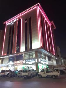 un gran edificio con coches estacionados frente a él en دار الكيان للشقق المخدومة - Dar Al Kayan Serviced Apartments en Yeda