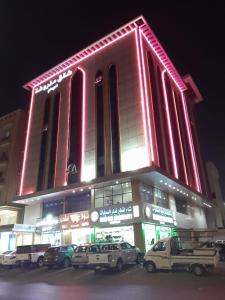 un grand bâtiment avec des voitures garées devant lui dans l'établissement دار الكيان للشقق المخدومة - Dar Al Kayan Serviced Apartments, à Djeddah