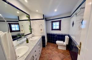a blue and white bathroom with a toilet and a sink at Casa Ignacio in El Río