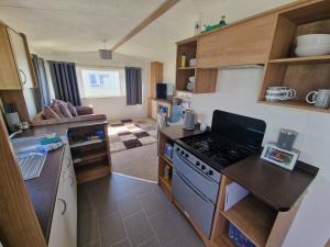 a small kitchen with a stove and a counter top at B17 Sunnymede Caravan Park, Fantasy Island, Ingoldmells in Ingoldmells