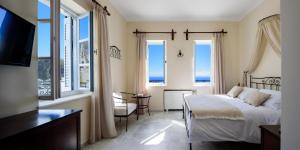 a bedroom with a bed and a view of the ocean at Ikio Concept Santorini in Pirgos