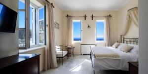 una camera da letto con un letto e vista sull'oceano di Ikio Concept Santorini a Pyrgos
