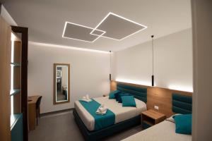 sypialnia z niebieskim łóżkiem i lustrem w obiekcie Room and Breakfast Aloe w mieście San Vito lo Capo