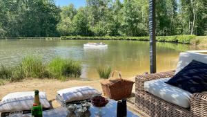 a boat in the water with people in a boat on a river at 'Hotel One Suite' Suite with Private Beach, Natural Swimming Pool & Reserve in Neung-sur-Beuvron