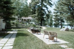 a patio with chairs and a table in the grass at Northridge Inn & Resort in Sundridge