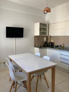 a kitchen with a white table and white chairs at Departamento en PLAYA GRANDE in Mar del Plata