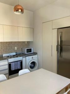 馬德普拉塔的住宿－Departamento en PLAYA GRANDE，厨房配有冰箱和洗衣机。