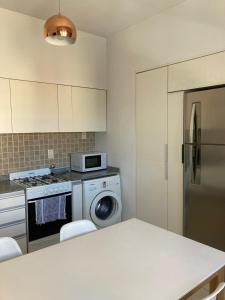 a kitchen with a refrigerator and a washing machine at Departamento en PLAYA GRANDE in Mar del Plata
