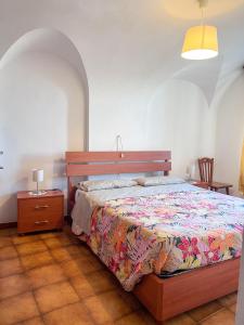 ein Schlafzimmer mit einem Bett, einem Tisch und einem Stuhl in der Unterkunft Orchidea in Finale Ligure
