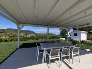 a patio with a table and chairs under a pergola at Le Nereidi Green Resort Elisa in Sirolo