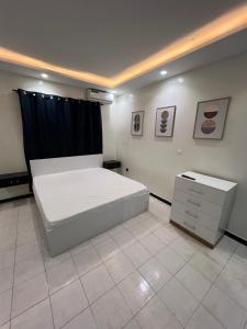 1 dormitorio con 1 cama blanca grande y vestidor en Le petit duo, en Dakar