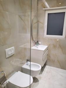 a white bathroom with a toilet and a sink at Central Luxe Apartment in Tirana