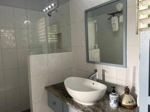 La salle de bains est pourvue d'un lavabo blanc et d'un miroir. dans l'établissement Modern apt with view and easy beach access, à Port Elizabeth