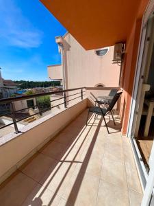 a balcony with a table and chairs on a building at Apartments Dante Domus Aurea in Milna