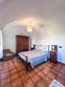 a bedroom with a bed and a chair at Orchidea in Finale Ligure