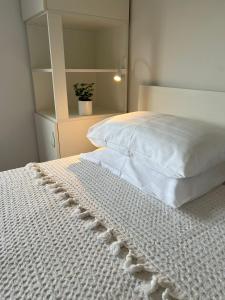1 dormitorio con 1 cama con colcha blanca en Apartments Dante Domus Aurea, en Milna
