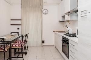 cocina con mesa, sillas y reloj en [5 min Lake Orta] Free parking, en Gozzano