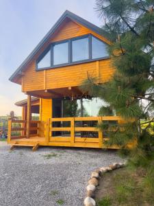 una gran casa de madera con una valla y un árbol en PrzyStań pod Łysą Górą, en Bostów