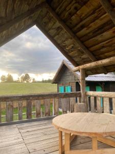 a wooden deck with a wooden table and a barn at Cottages of Nišići in Sarajevo