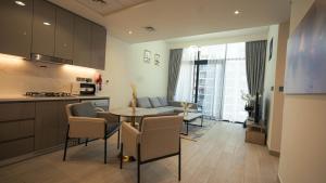Una cocina y una sala de estar con mesa y sillas. en Aaderi Homes, en Dubái