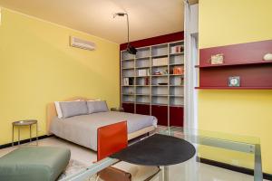 1 dormitorio con cama y mesa de cristal en [5 min Lake Orta] Free parking, en Gozzano