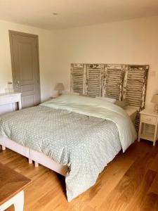 a bedroom with a large bed and a wooden floor at La Chambre du Saule in Trévières