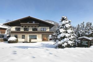 una casa cubierta de nieve con nieve Árbol de Navidad cubierto en Appartement Lackner, en Zell am See