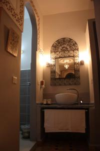 a bathroom with a sink and a mirror at Ryad Meknassia in Meknès
